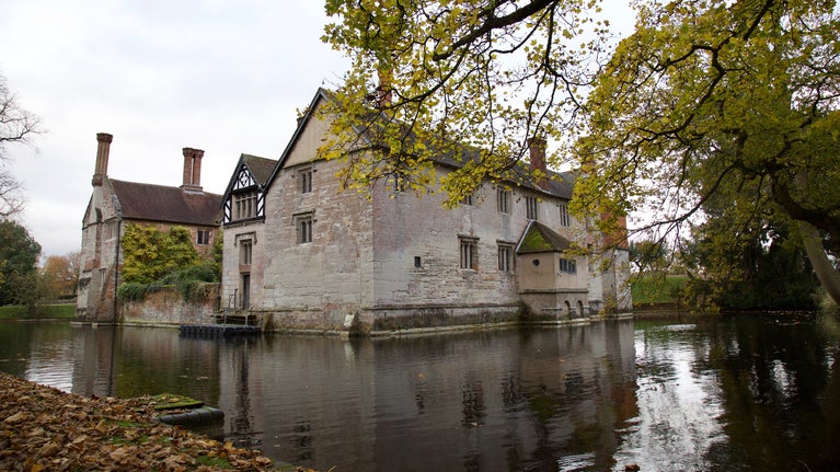 Baddesley Clinton, Warwickshire, reflected in the moat in the autumn sunshine